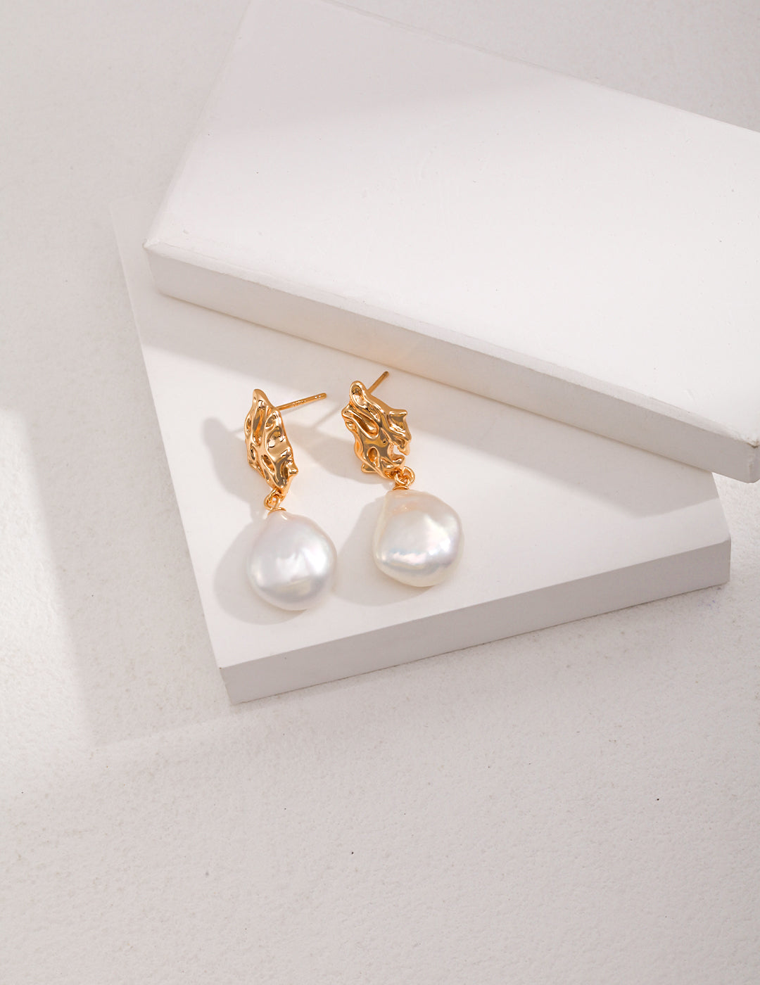 Elegant gold earrings with a pearl drop, featuring cute, dreamy baroque pearls for a stylish touch.