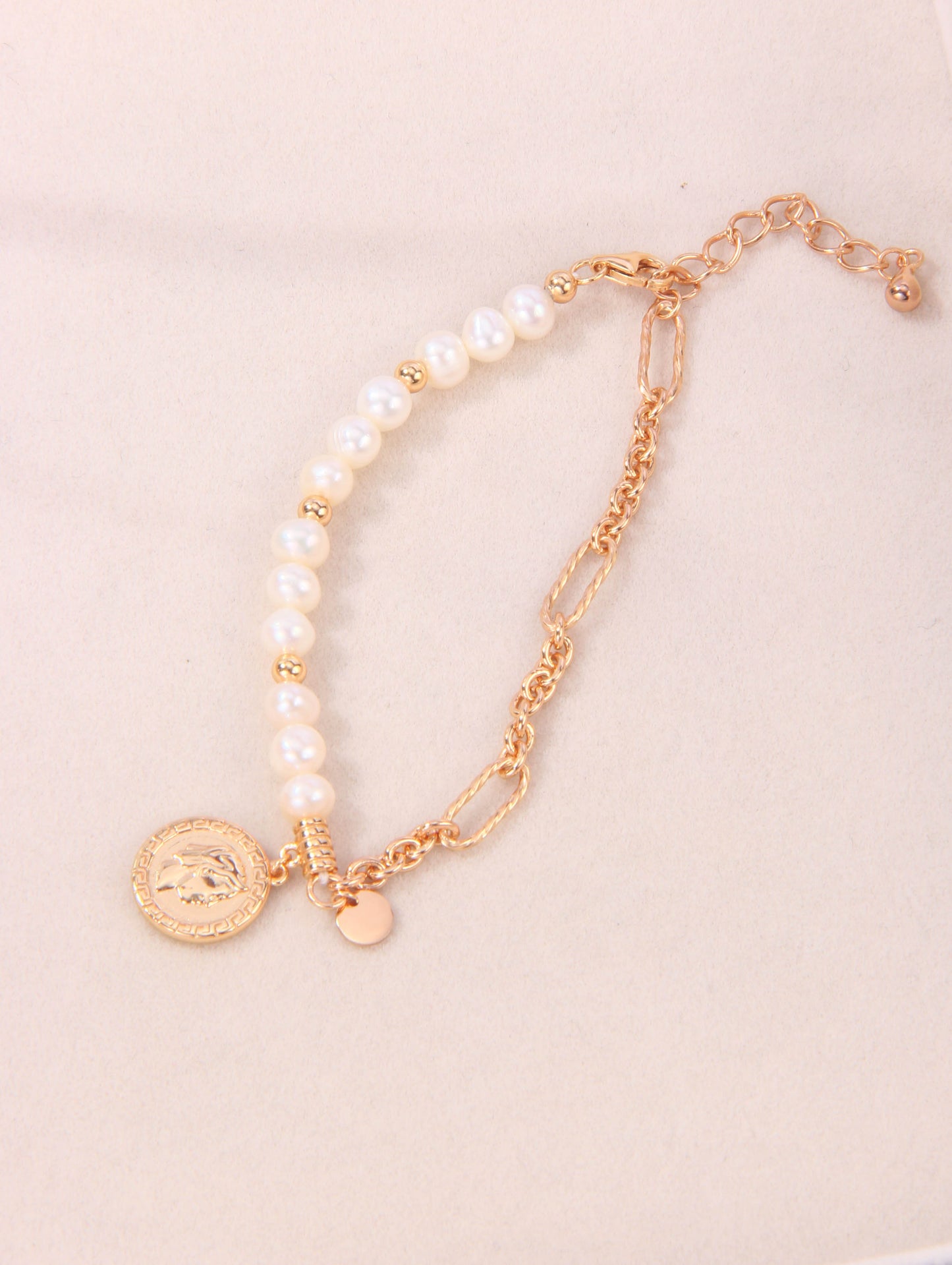 A gold-plated bracelet featuring a stylish coin charm, perfect for adding elegance to any outfit.