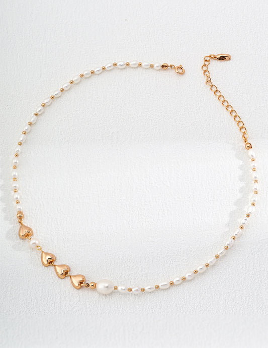 An exquisite gold and white pearl necklace laid out on a white surface, emphasizing its refined beauty and craftsmanship.