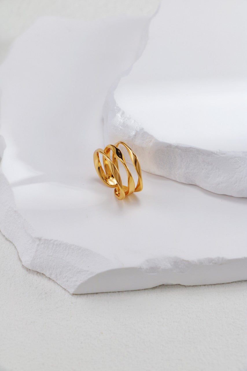 A beautifully crafted gold open triple layer ring showcased on a clean white surface.