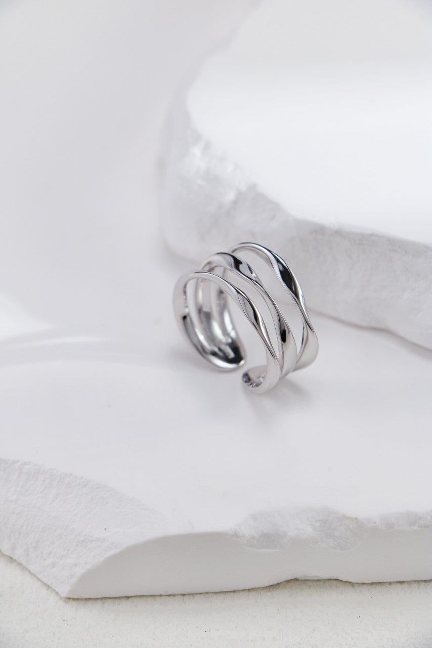 Elegant silver ring with a twisted design on top, featuring an open triple-layer style for a unique and modern look.