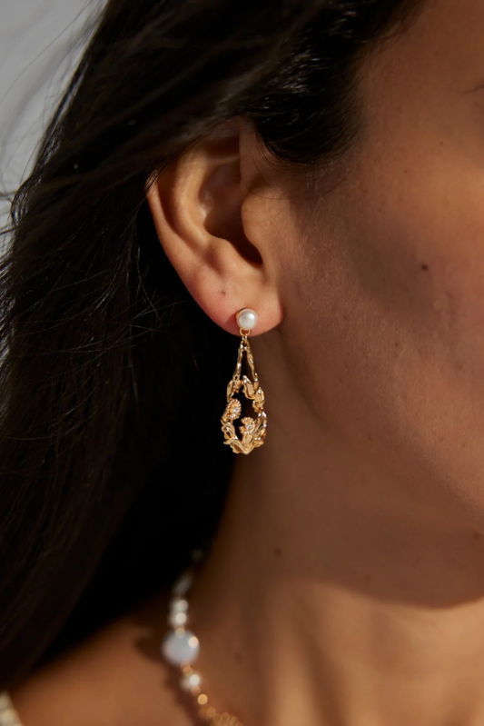 Elegant gold earrings featuring lustrous pearls, showcasing a beautiful blend of luxury and sophistication.