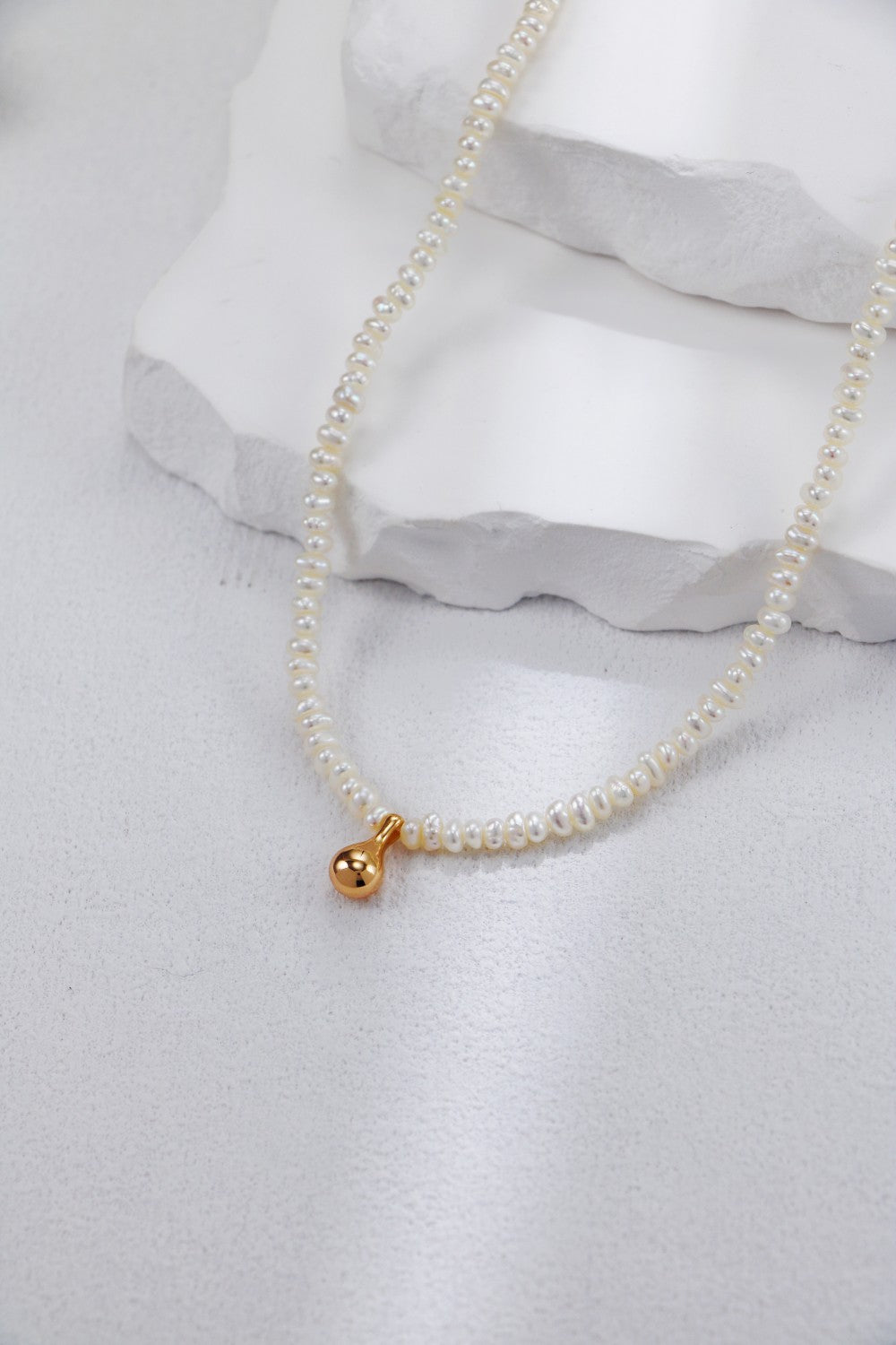 Beautiful white pearl necklace with a gold charm, ideal for enhancing your jewelry collection with classic elegance.