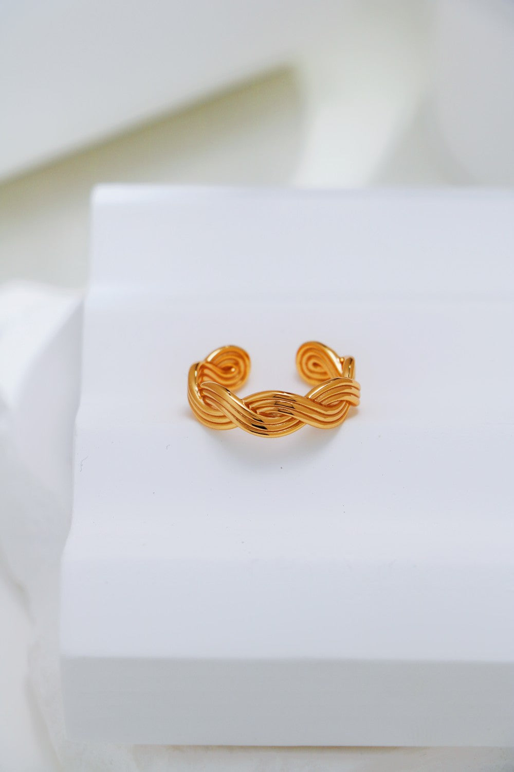 An exquisite gold ring with a spiral braid design, combining elegance and artistry in a beautiful piece of jewelry.