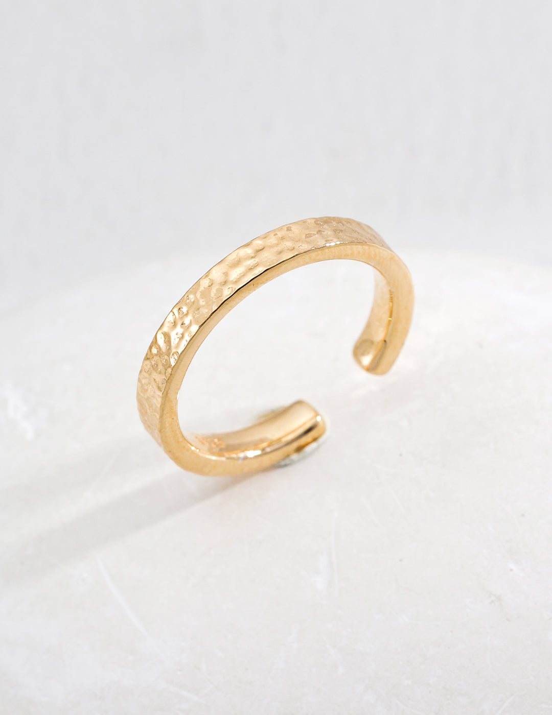 A sleek gold ring with a delicate curved design, highlighting its modern elegance and refined aesthetic.