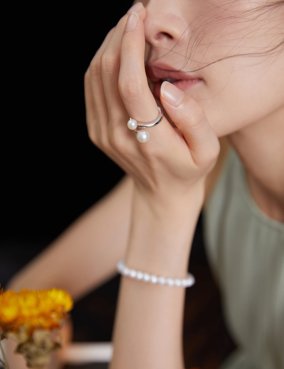 Woman wearing silver wrap around ring with freshwater pearls and matching bracelet.