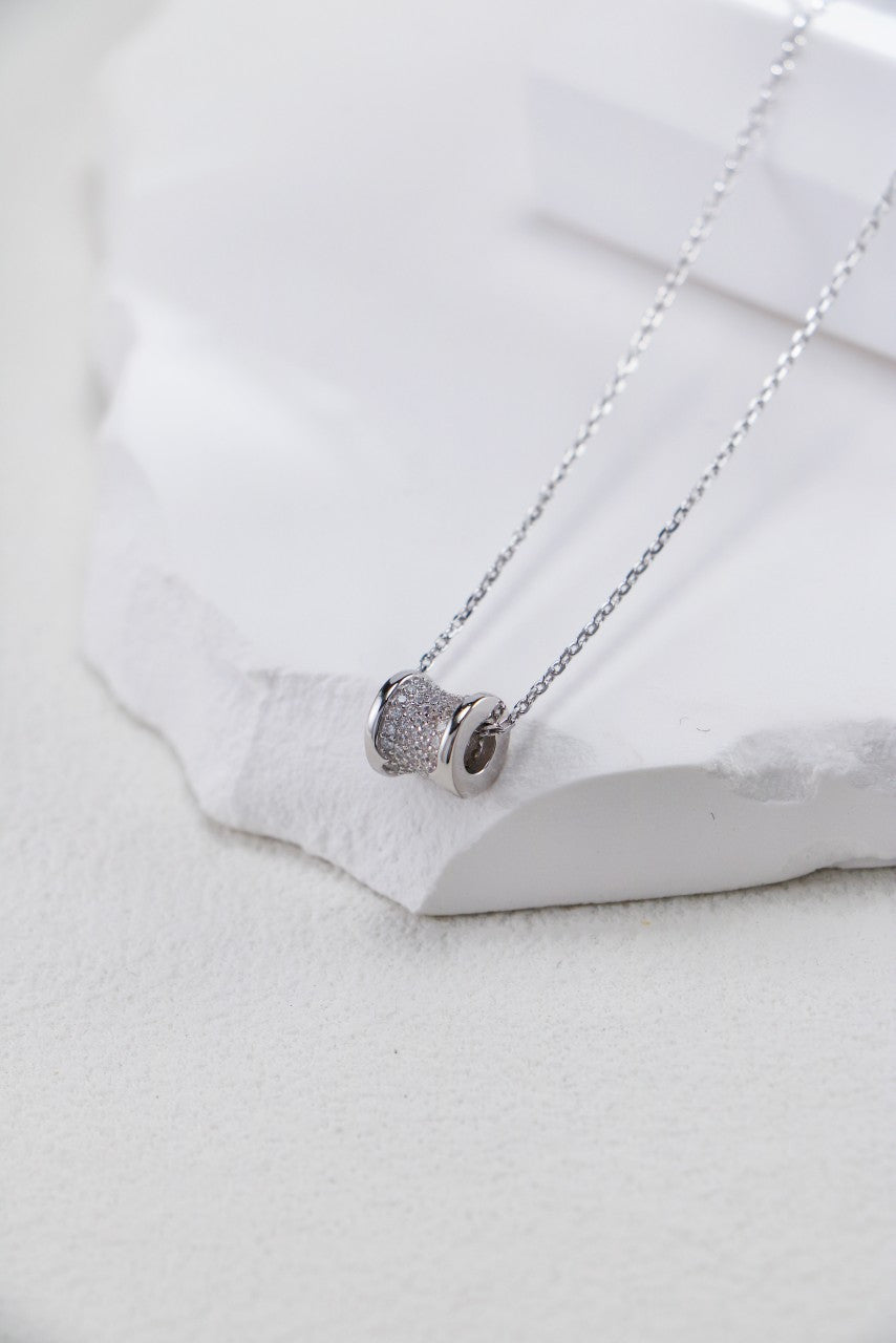 Elegant silver necklace adorned with a spiral pendant, symbolizing love and connection in a timeless design.