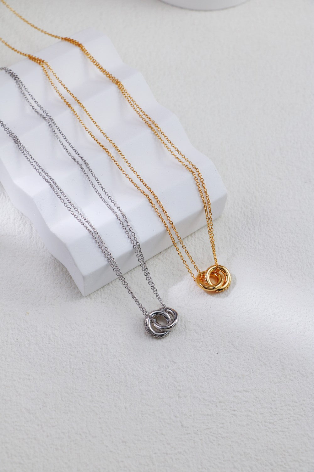 Two elegant chain necklaces, each with small circles, featuring a stylish double link design in both silver and gold.