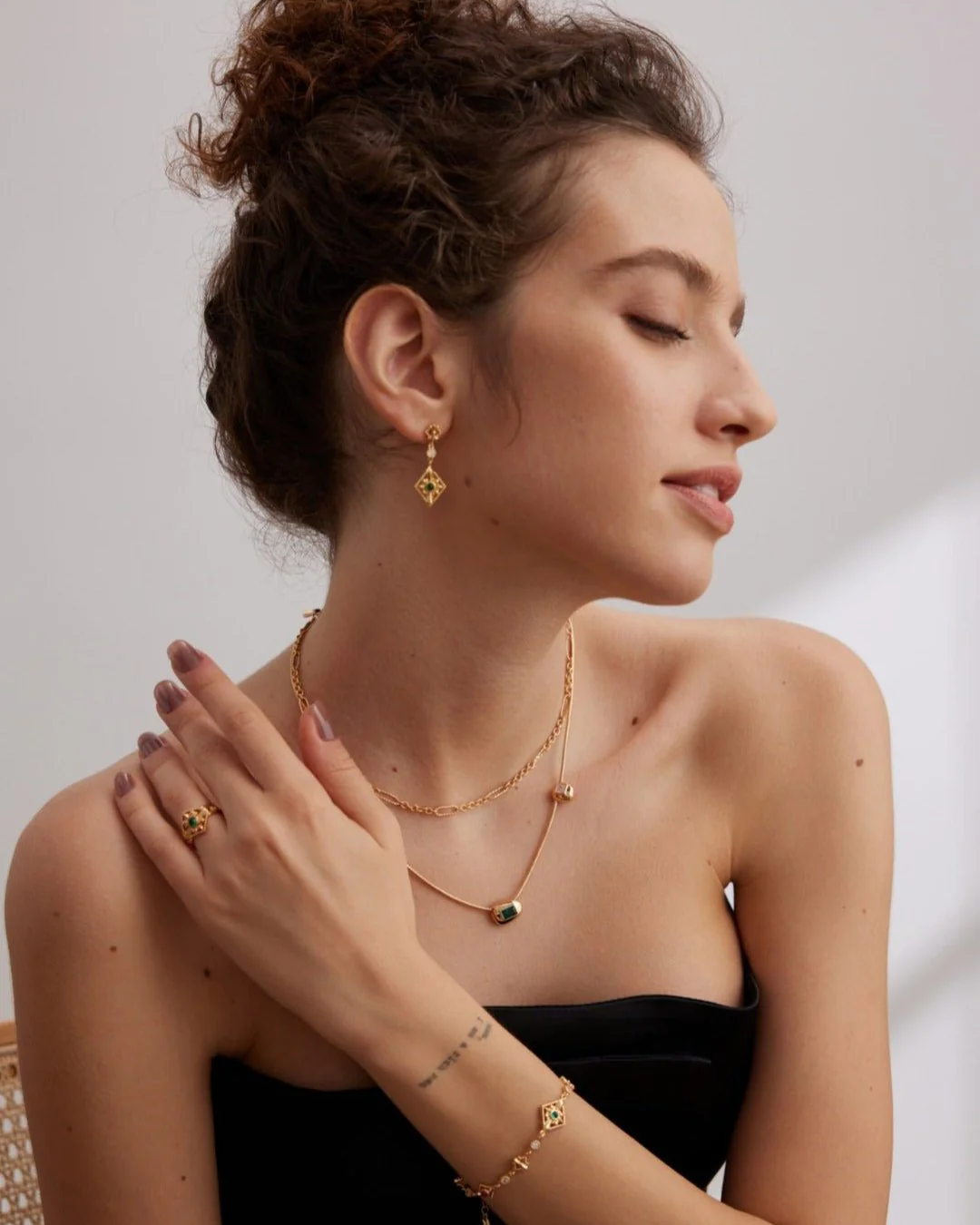A woman in a stylish black dress and gold jewelry, embodying a sophisticated princess aesthetic.