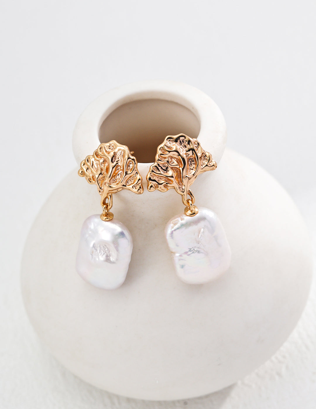 Stunning gold earrings adorned with white pearls, offering a timeless and sophisticated look.