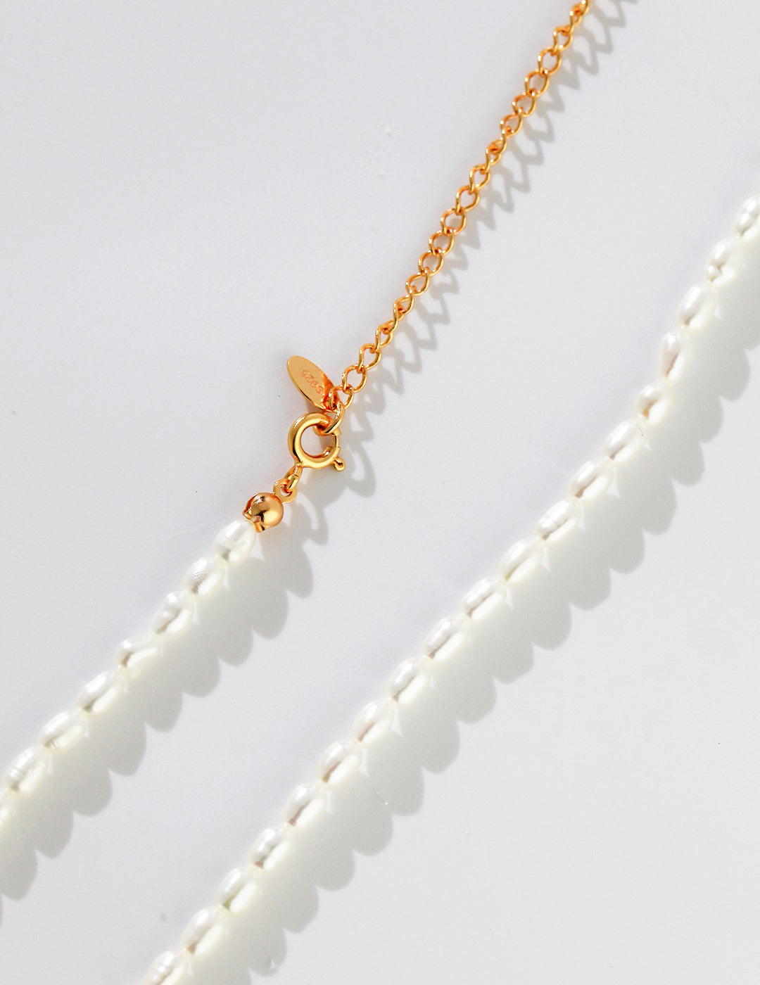 Close up shot of a gold-plated rice pearl necklace.