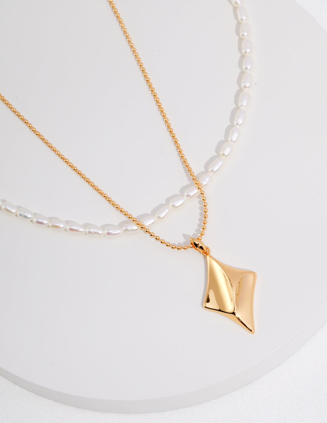 Elegant two-tier gold necklace with pearl and gold pendants