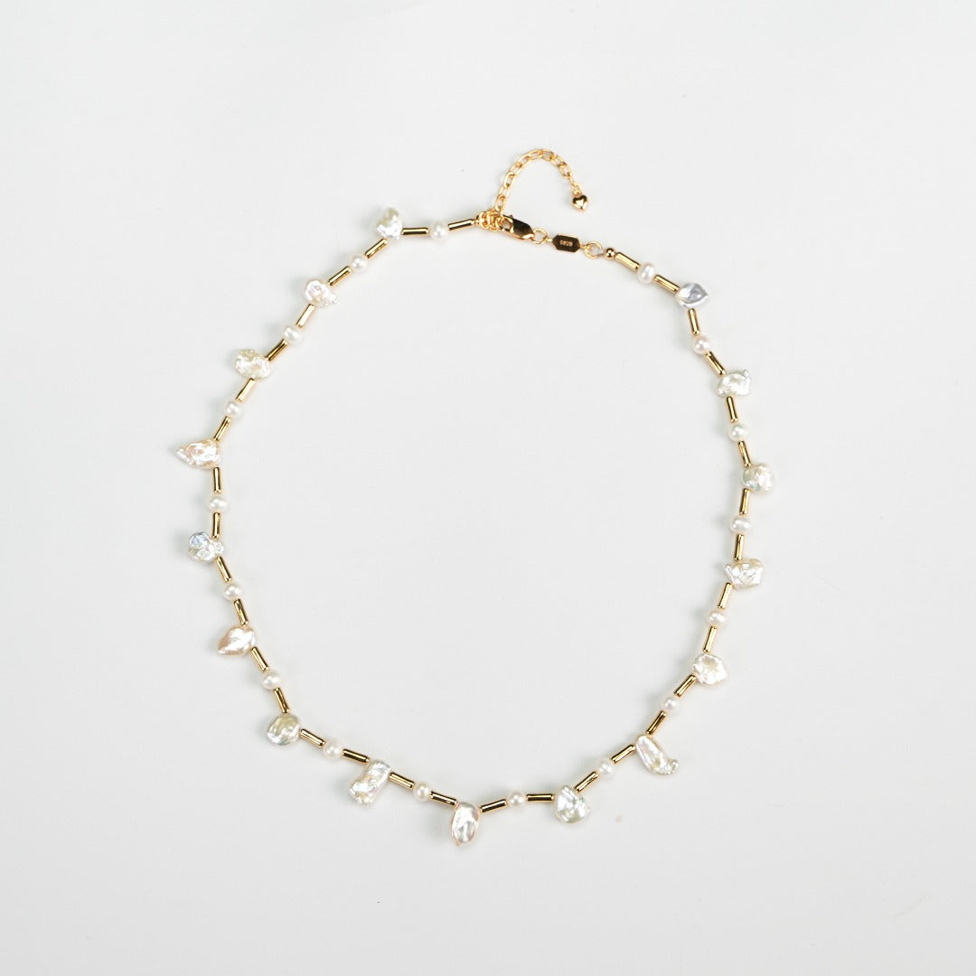 Timeless gold necklace with a chain of small long beads, complemented by baroque and freshwater pearls for a feminine touch.