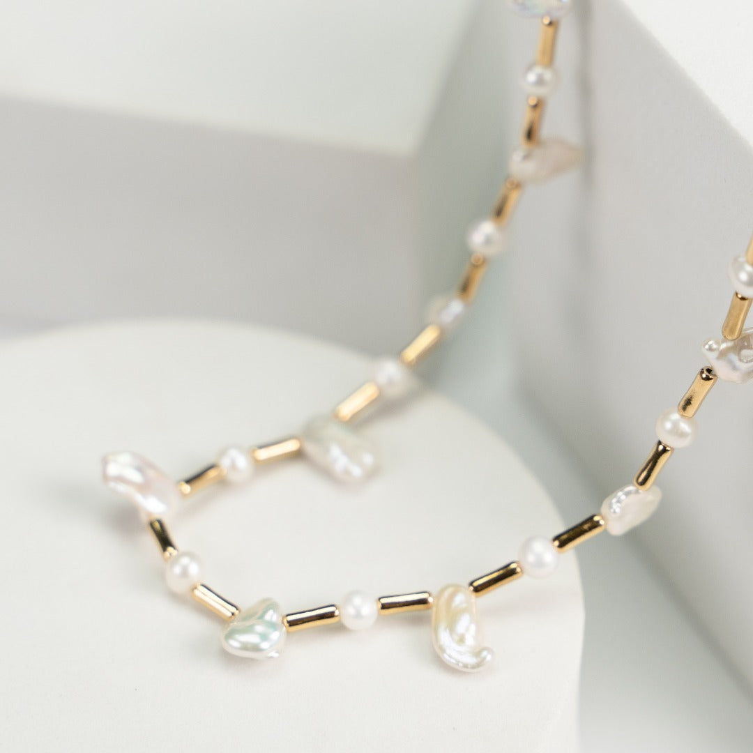 Dreamy necklace adorned with baroque and freshwater pearls, complemented by shimmering gold beads for an elegant touch.