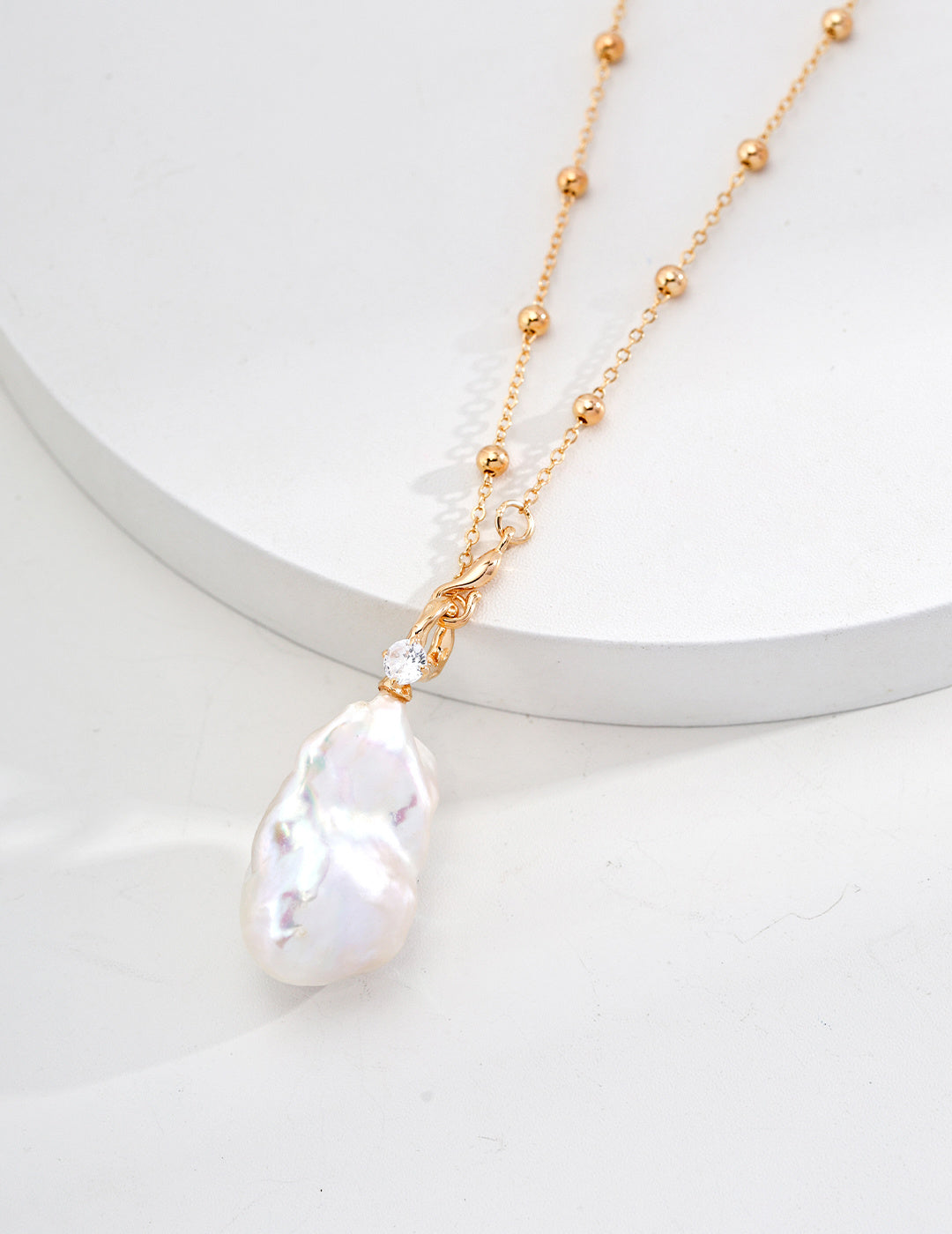 Elegant freshwater pearl necklace featuring a delicate gold chain, showcasing a lustrous white pearl in a stunning design.