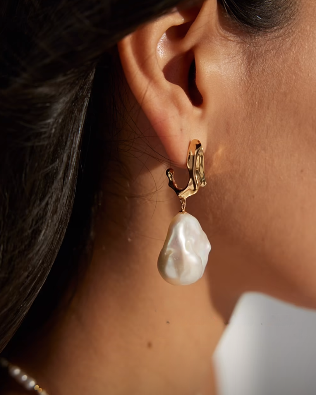 Elegant gold earrings featuring lustrous pearls, showcasing a classic and sophisticated design.