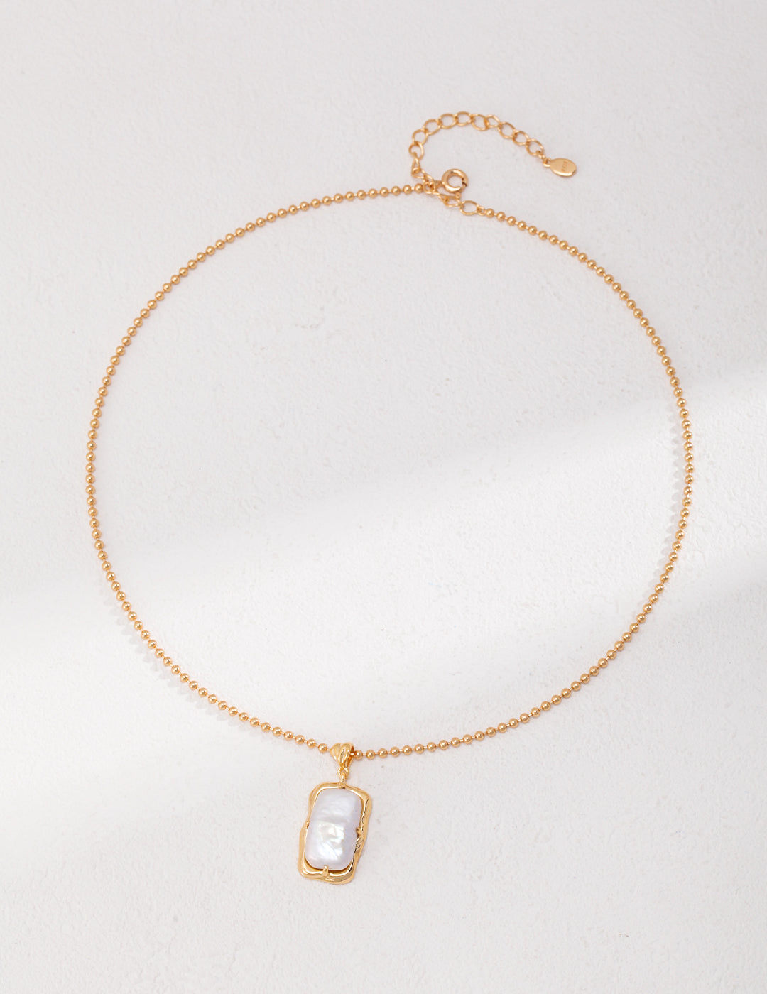 Luxurious gold plated necklace adorned with a single freshwater pearl.