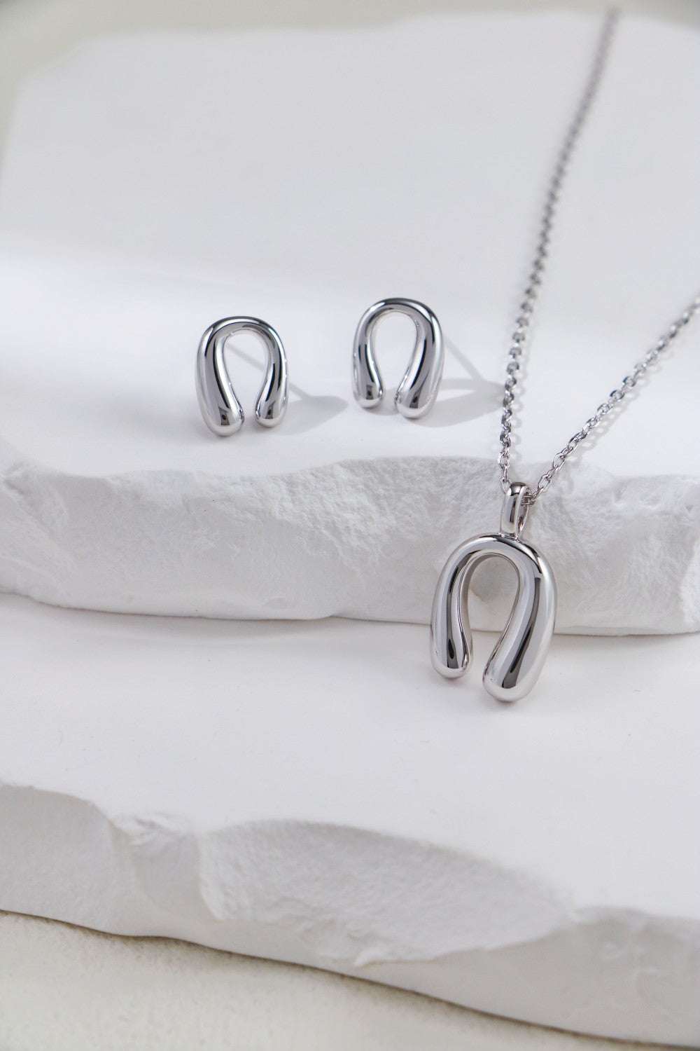 Elegant silver horseshoe earrings and necklace set, perfect for adding a touch of charm to any outfit.
