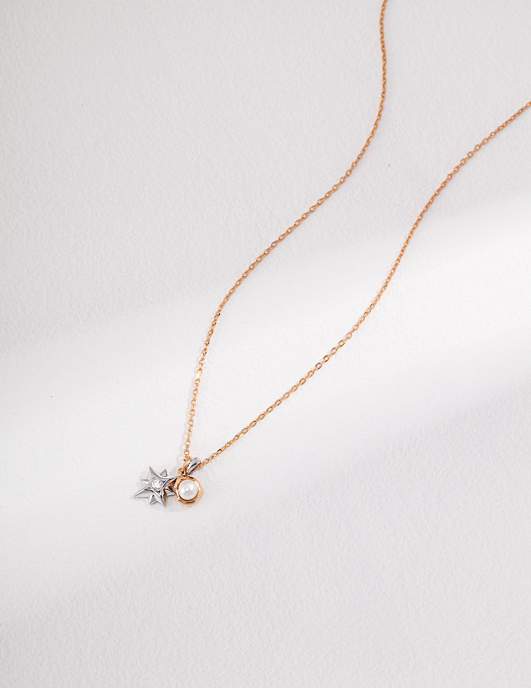 A gold chain necklace adorned with a star and a full moon charm, adding celestial elegance.