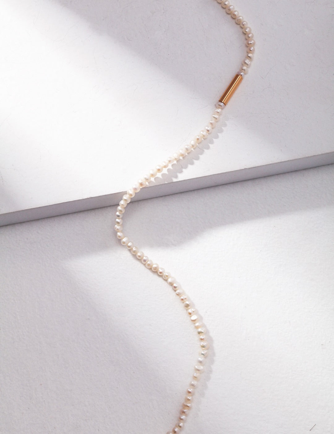 Beautiful pearl necklace complemented by a gold chain, embodying classic style and refined charm.