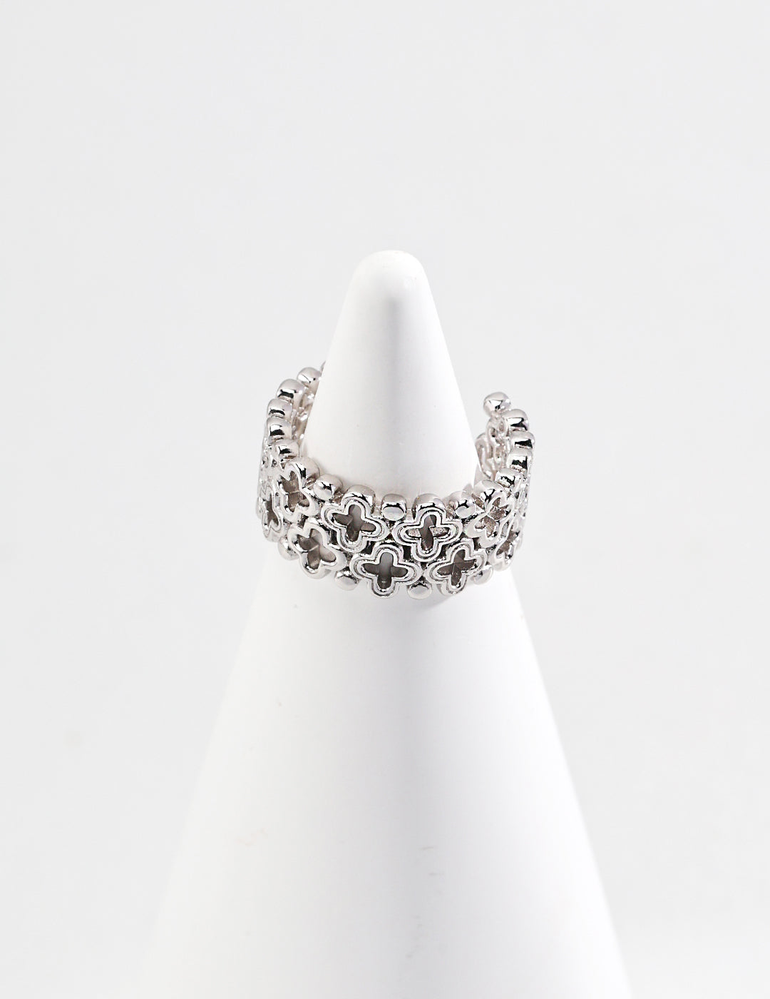 Elegant sterling silver ring with a hollow clover design, displayed atop a cone.