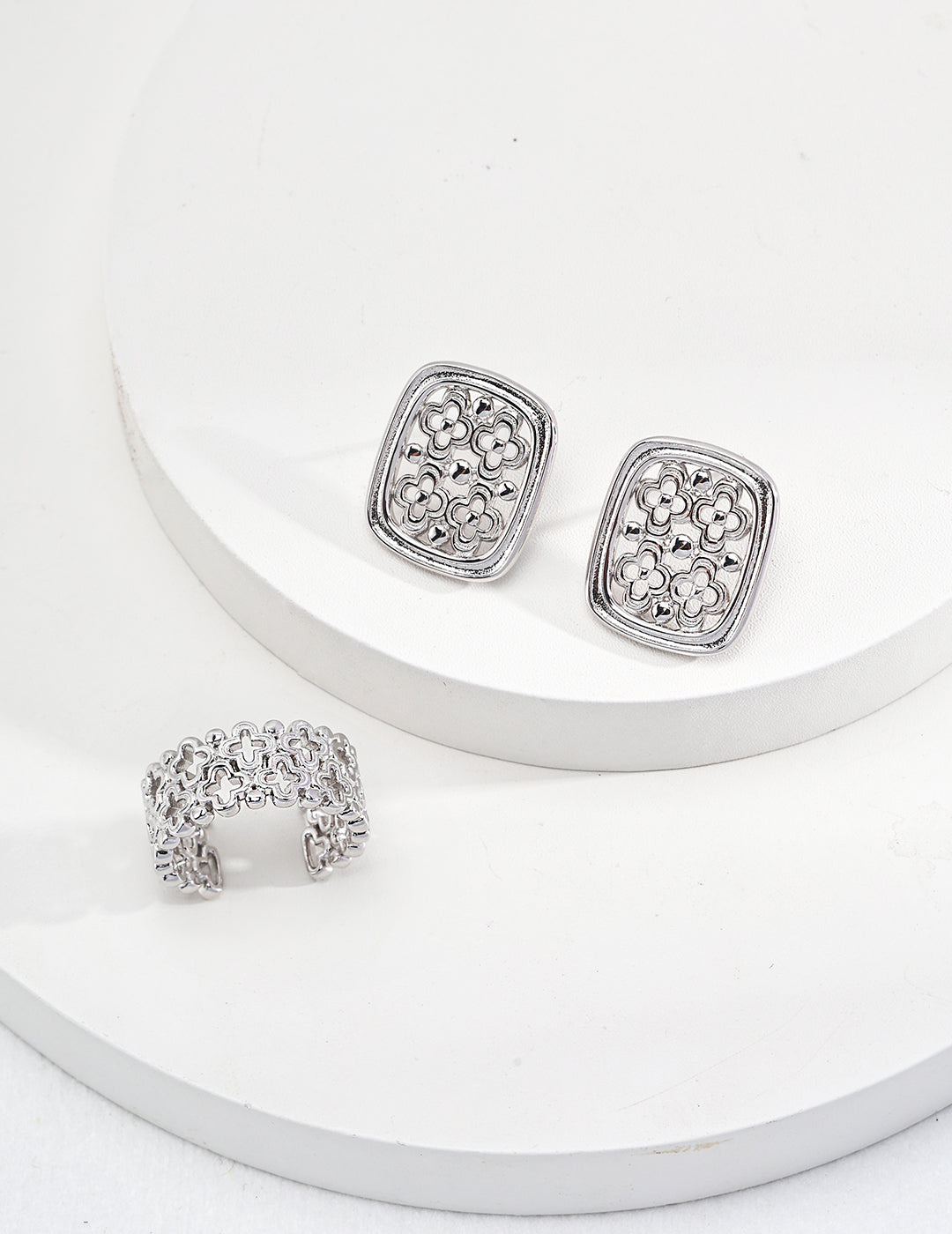 Elegant sterling silver earrings and a ring with a hollow clover design, showcasing vintage Chinese style.
