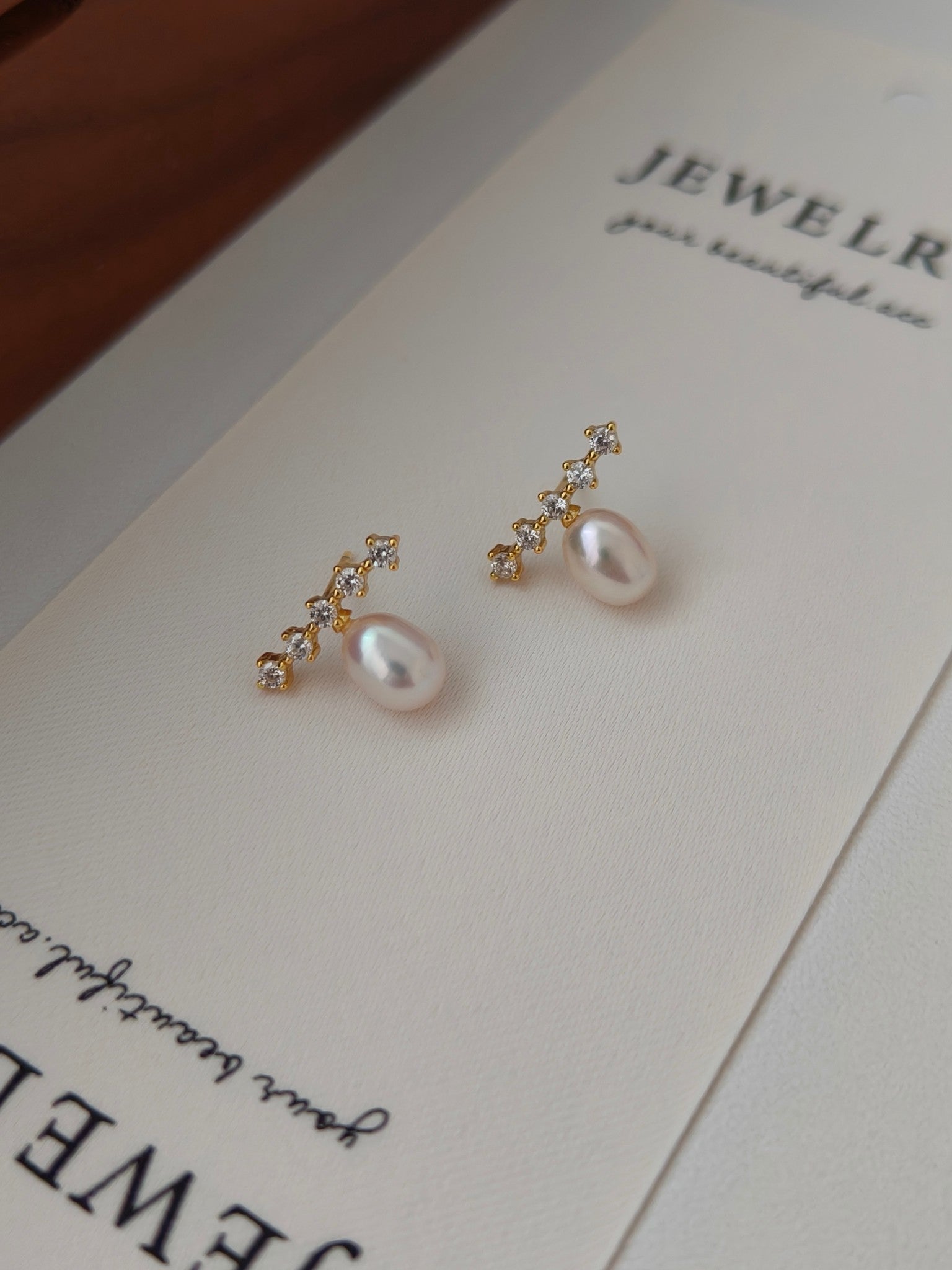 A pair of elegant earrings adorned with lustrous rice pearls and sparkling cubic zirconia.