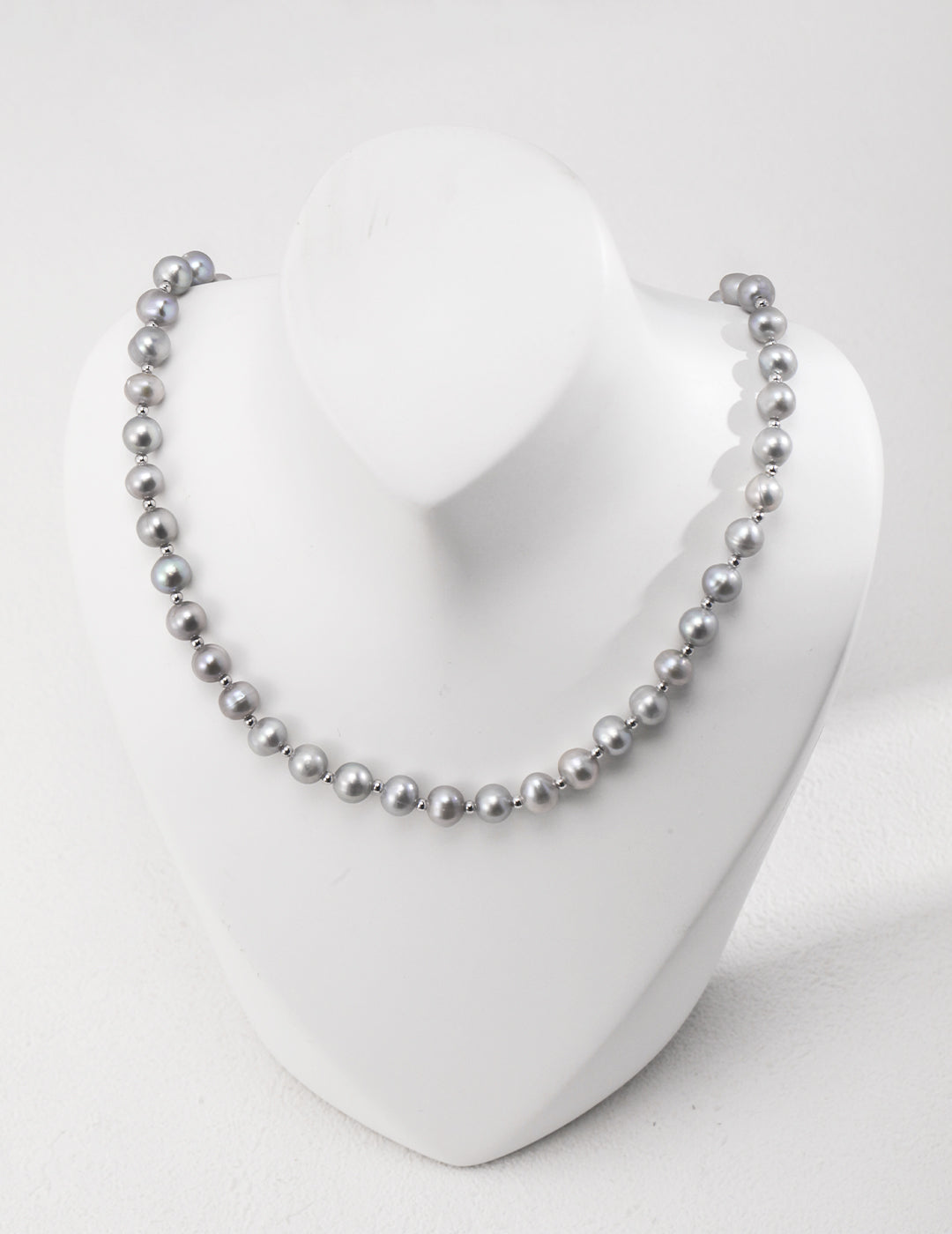 Enhance your style with a grey freshwater pearl necklace showcased on a white mannequin, exuding timeless beauty.