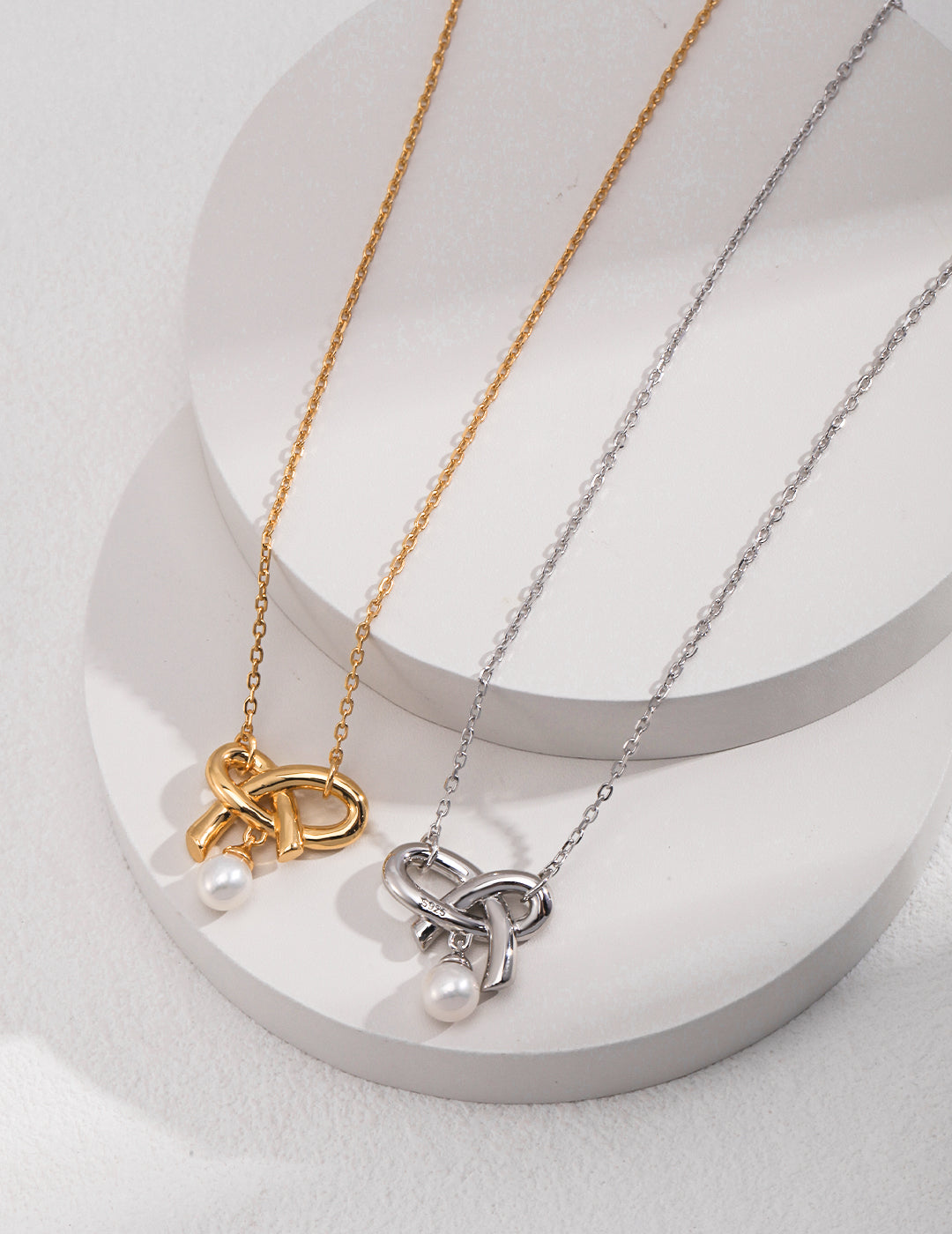 Enhance your style with these stunning silver and gold necklaces adorned with knot heart pearl pendant.
