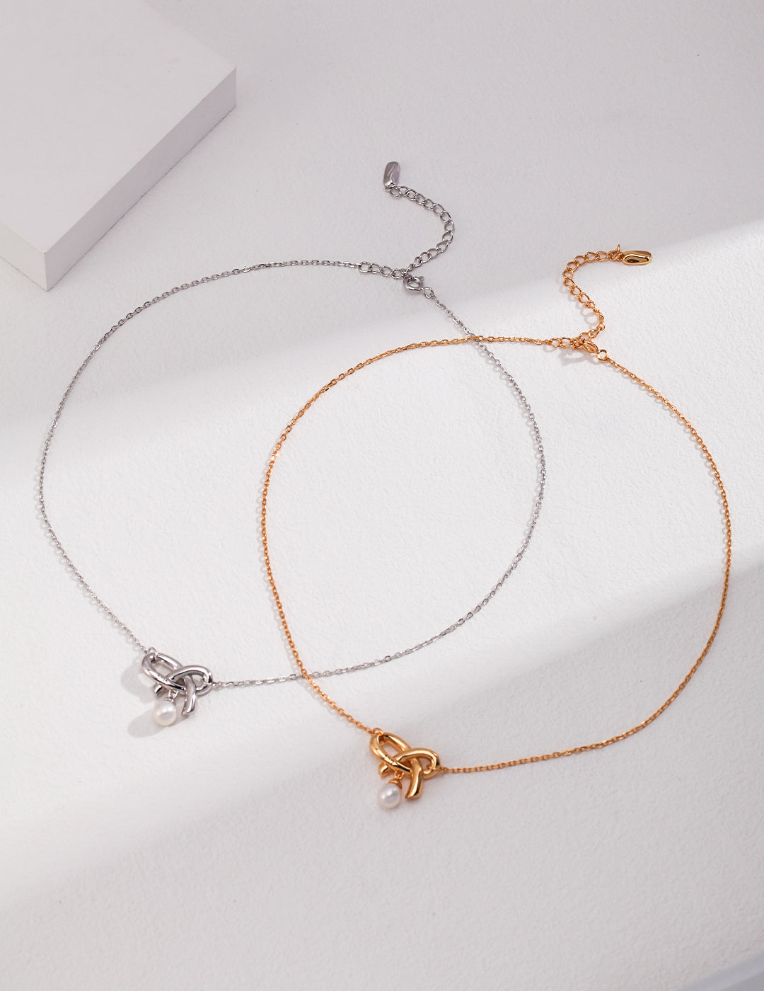 Elegant silver and gold pearl knot necklaces.