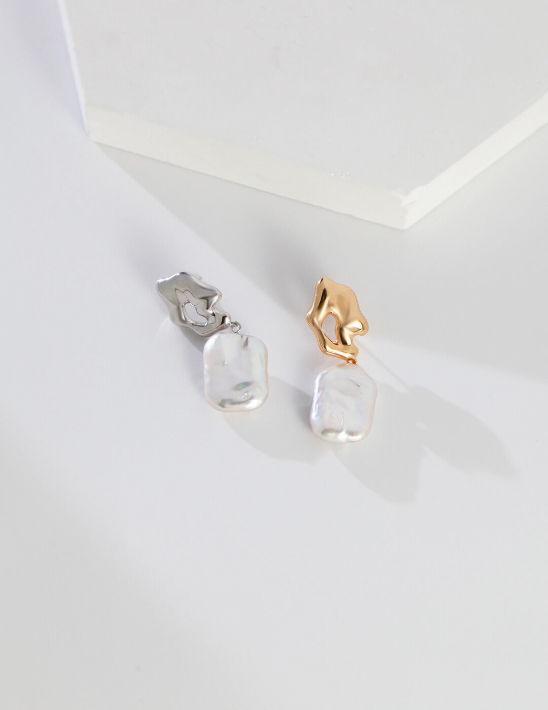 Stylish baroque pearl earrings with silver and gold accents.