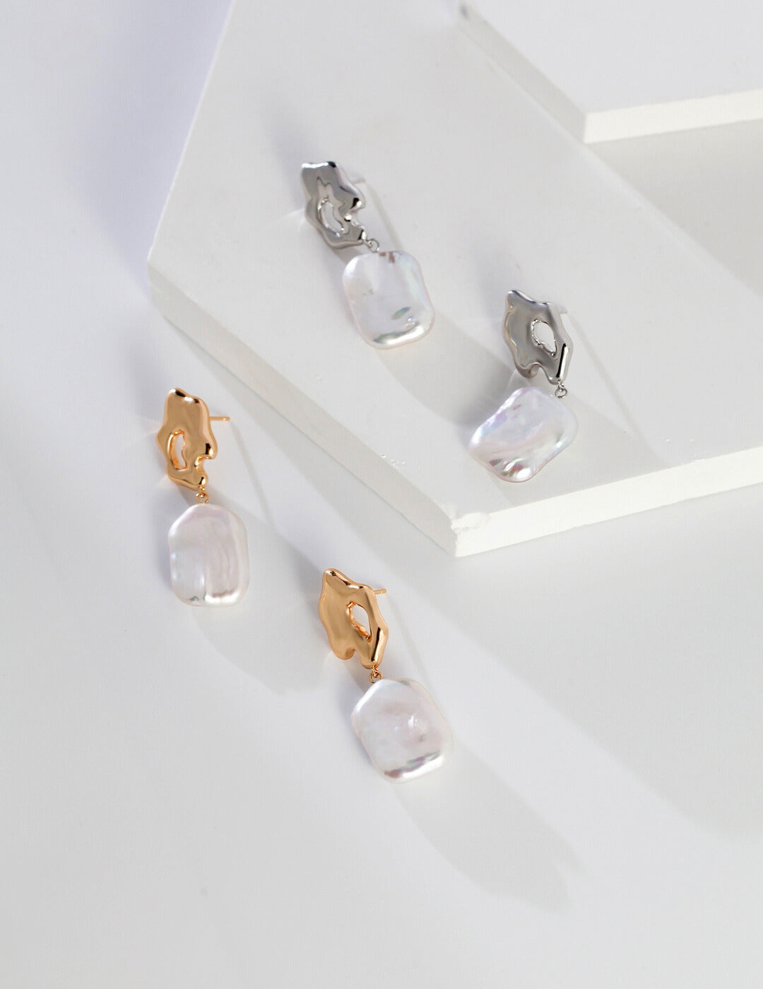 Enhance your style with these stunning earrings, adorned with baroque pearls in silver and gold, each in a distinct color.