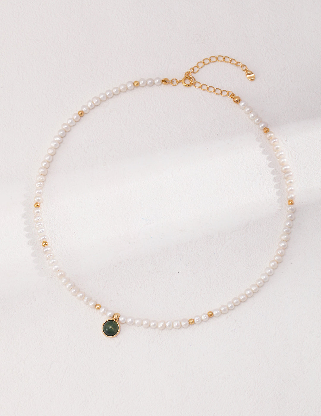 Vintage freshwater pearls necklace with agate pendant, gold charm, and green stone.