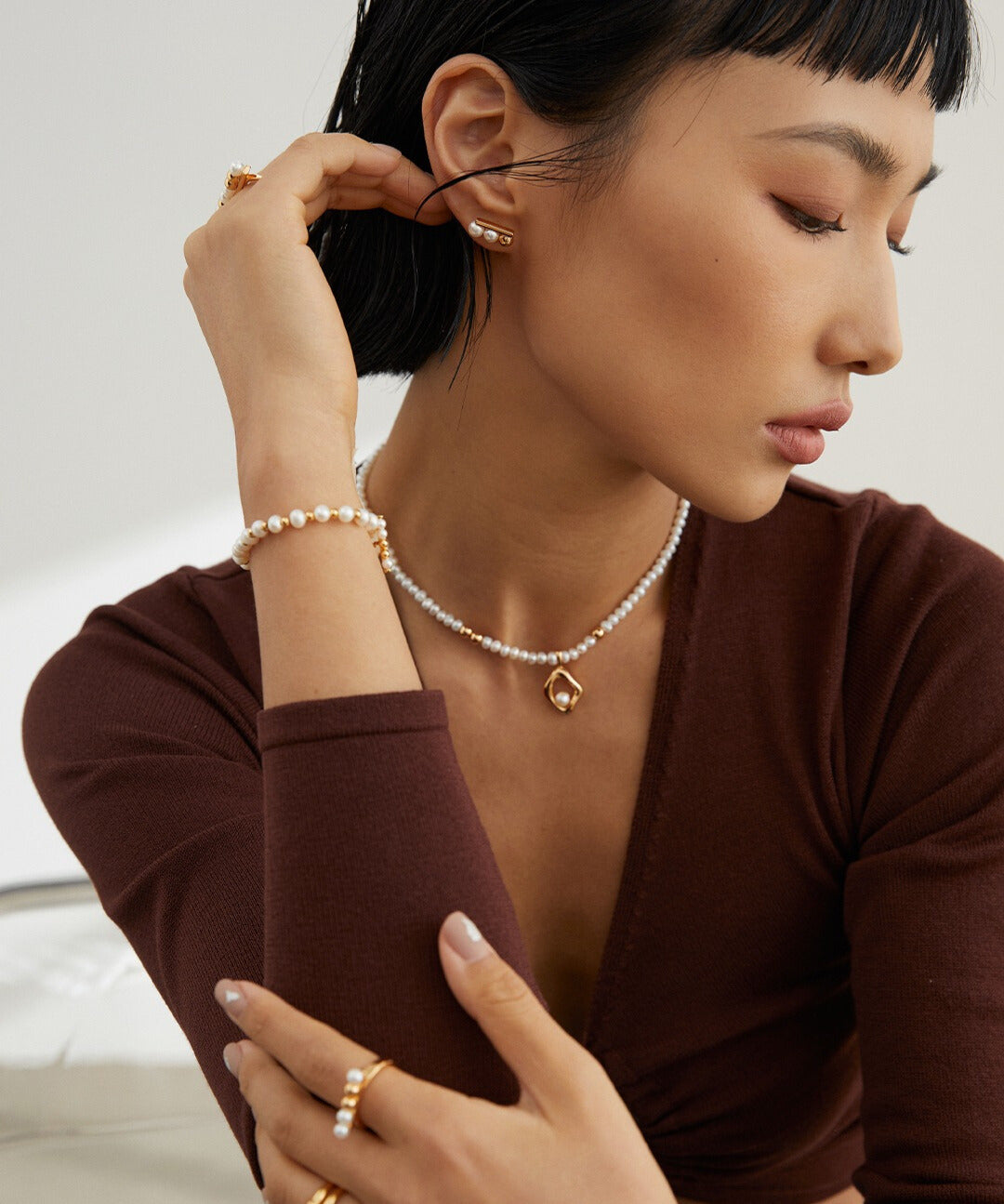 Woman wearing gold freshwater pearls bracelet and necklace.