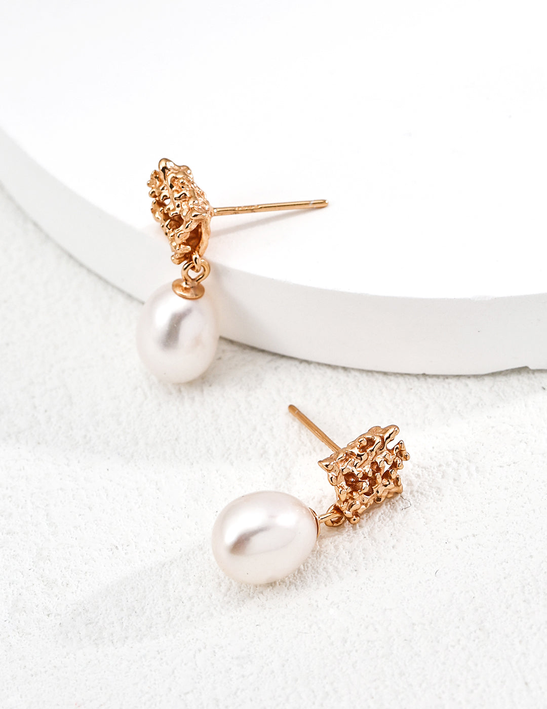 Luxe sculptural pearl earrings in gold and white gold, exuding an effortlessly expensive look.