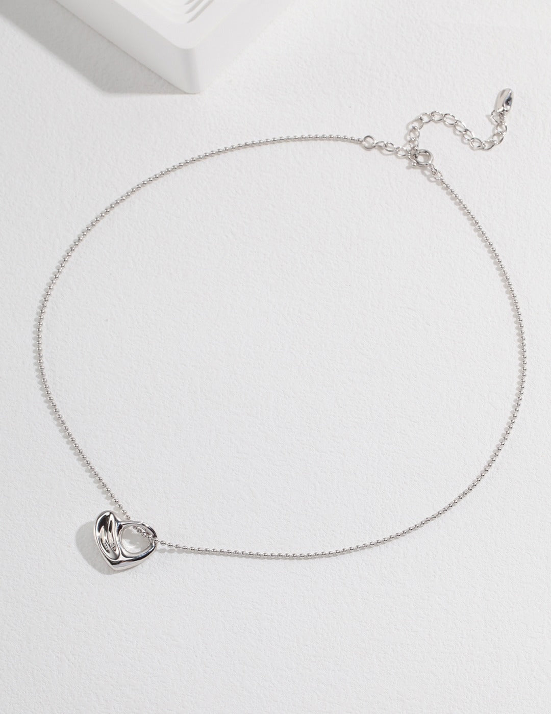 Shiny silver necklace with chubby heart pendant.