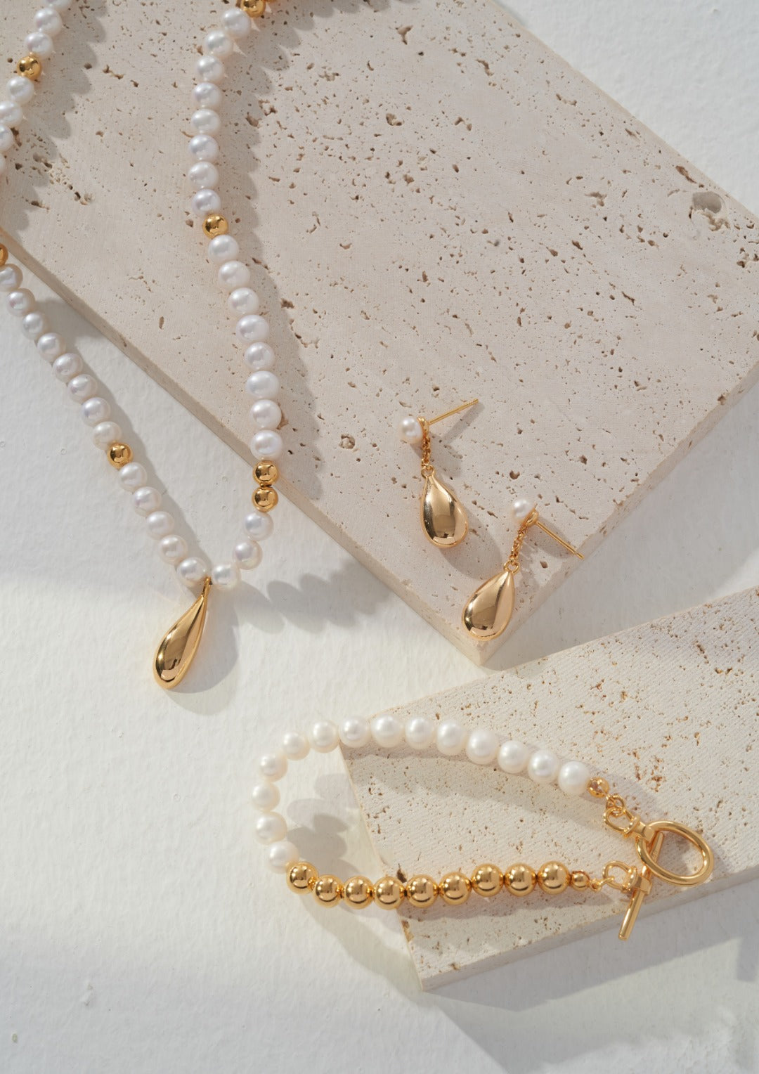 A stunning set of gold jewelry with freshwater pearls - necklace, earrings, and bracelet.