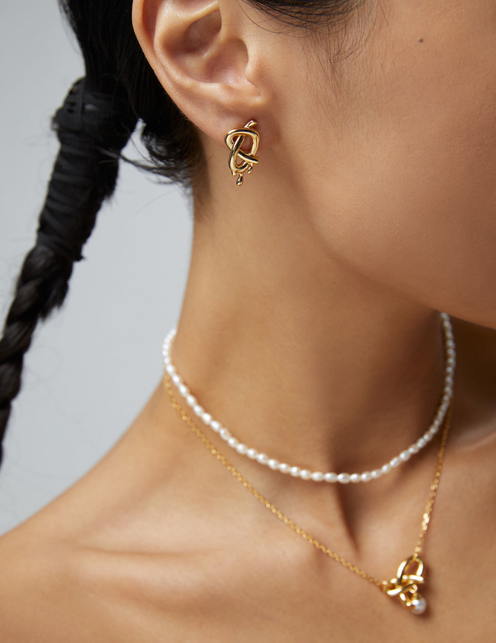 Close-up of model wearing gold and pearl jewelry from Mezuille.