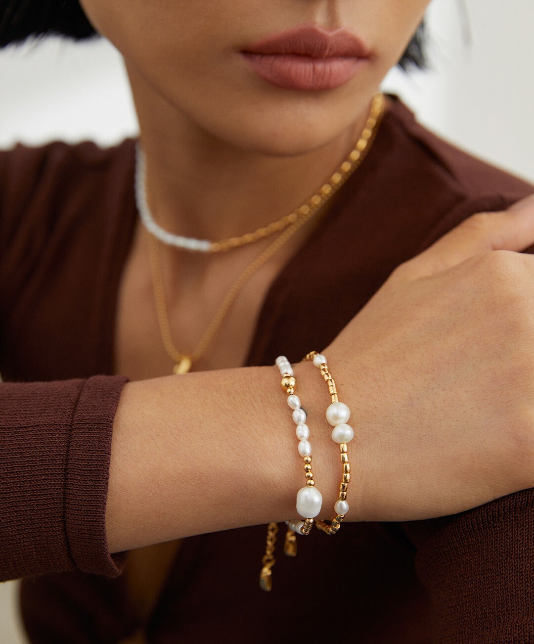 A model showcasing bracelets and a pearl necklace, featuring a stunning gold beaded freshwater pearls bracelet.