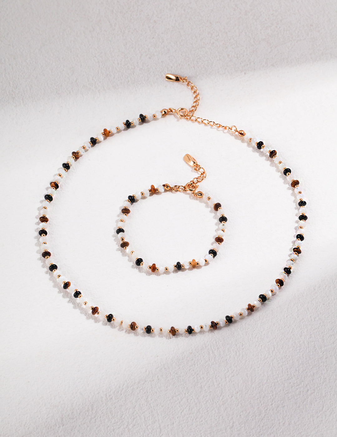 Matching necklace and bracelet with black and white beads, gold plated and silk beads, tiger's eye stones.