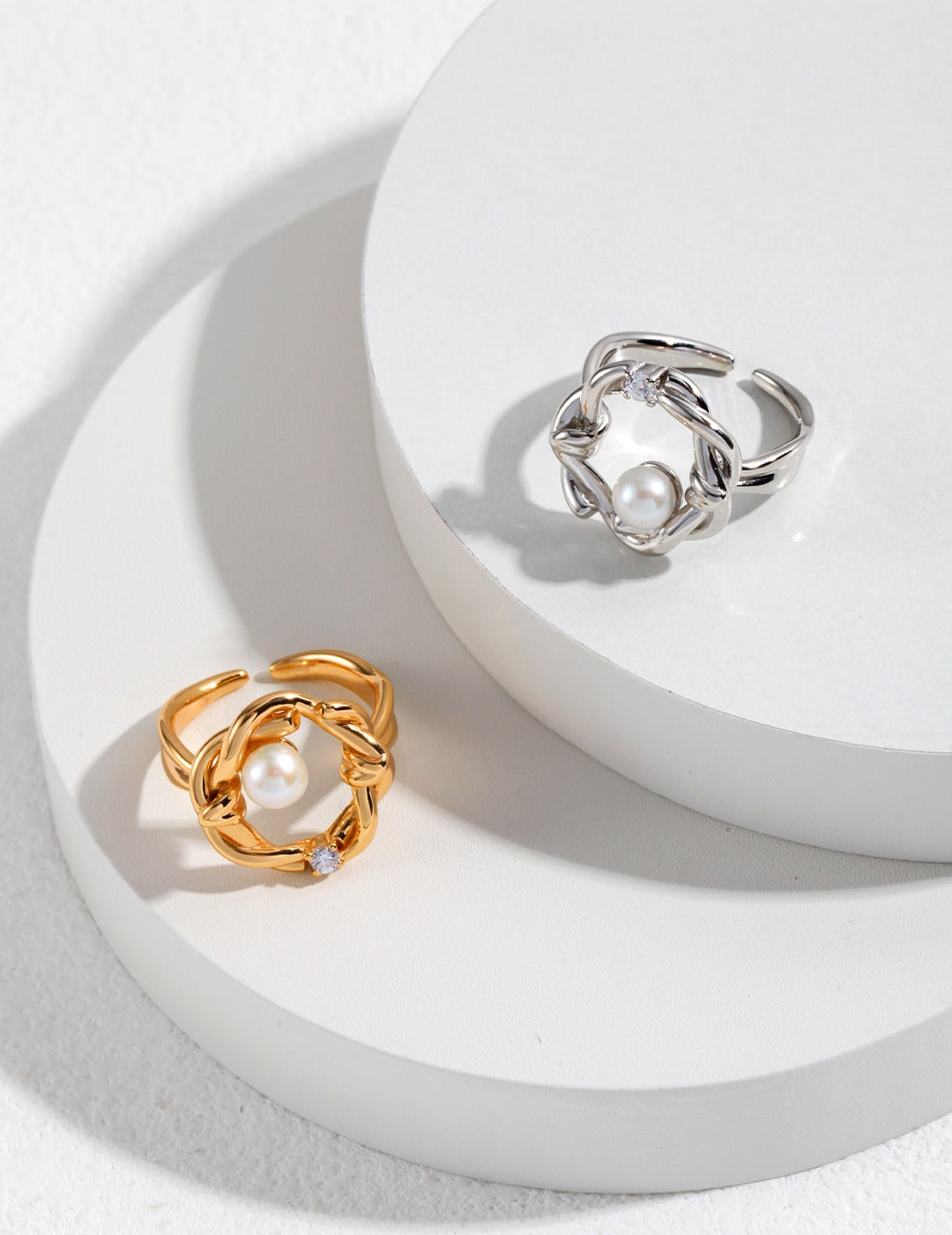 Two elegant rings featuring floral designs, freshwater pearls, and cubic zirconia, crafted in silver and gold.