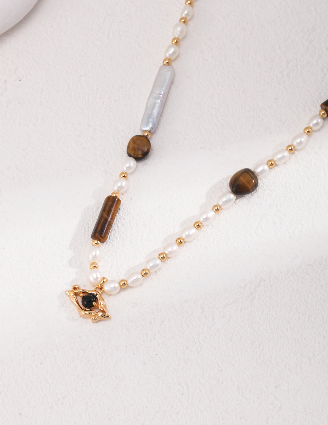 Gold plated necklace with tiger's eye stones, freshwater pearls, and black agate pendant.