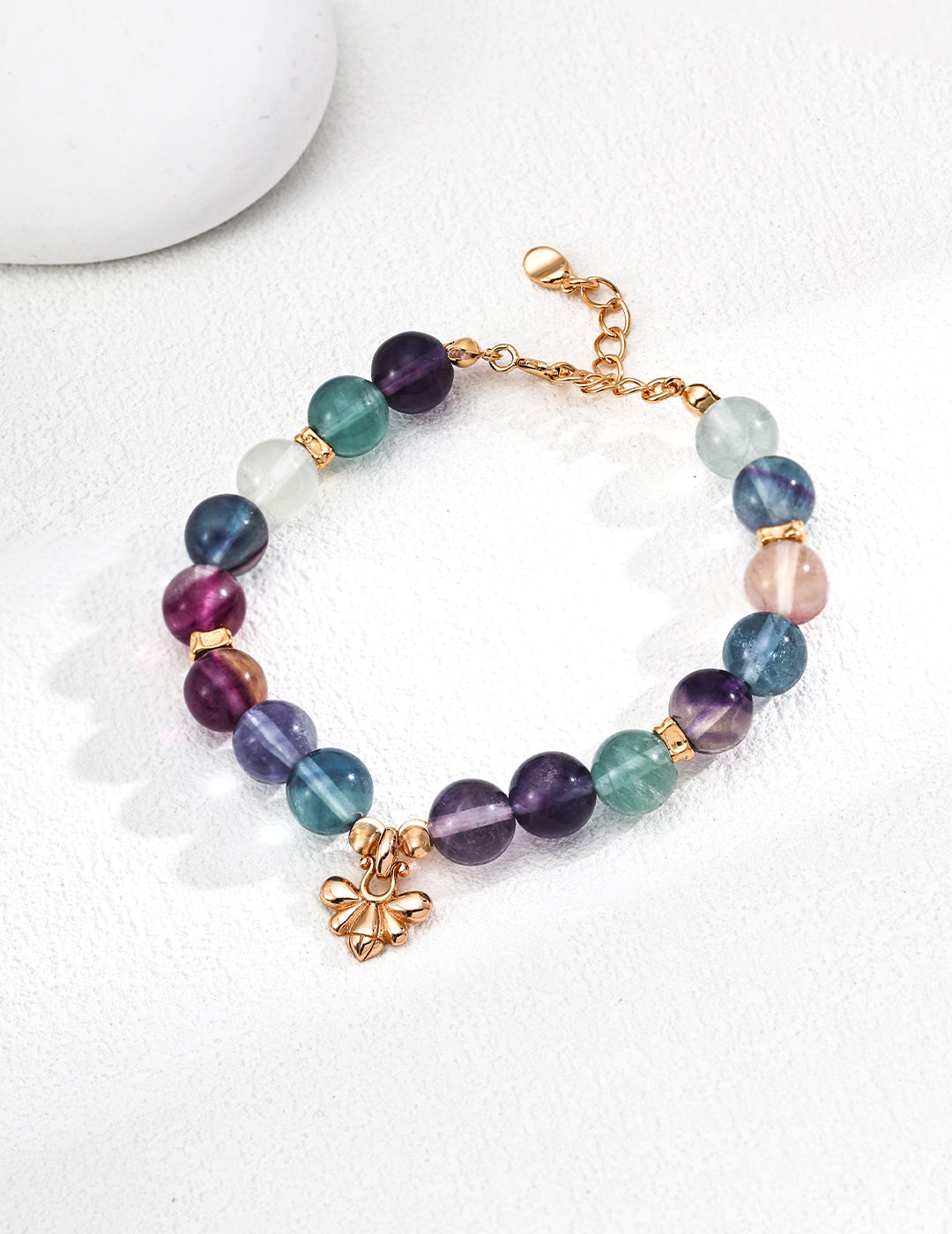 Multi-colored fluorite bracelet adorned with a gold-plated charm, offering a bright and eye-catching accessory.