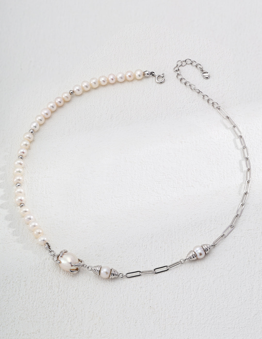 A stylish modern design of a white pearl necklace complemented by a chic silver chain, perfect for any occasion.
