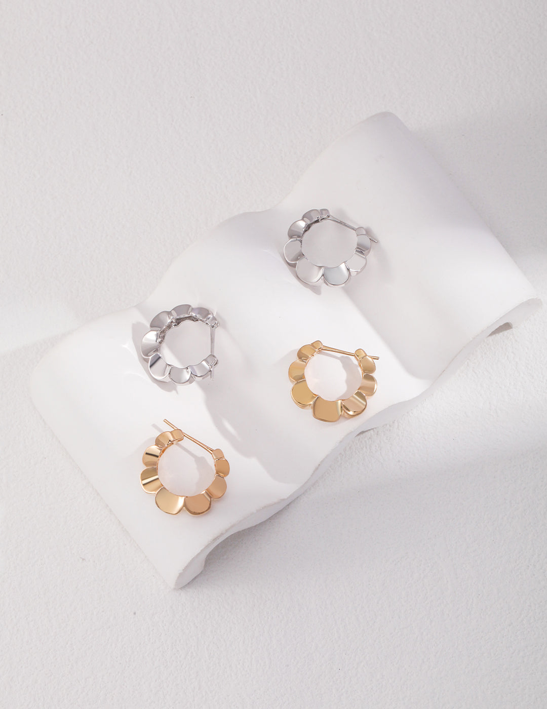 Elegant hoop earrings in gold and silver with beautiful floral shapes, ideal for a chic and sophisticated style.