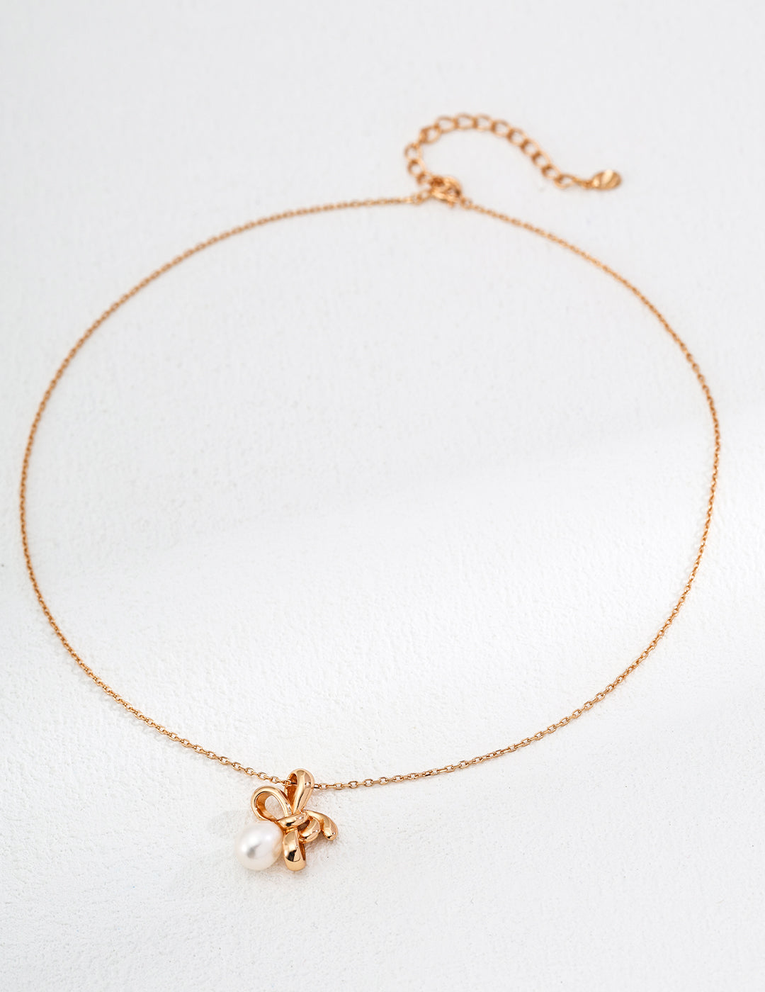 Gold necklace featuring a playful flower charm and a twist knot design, adding an effortlessly chic touch.