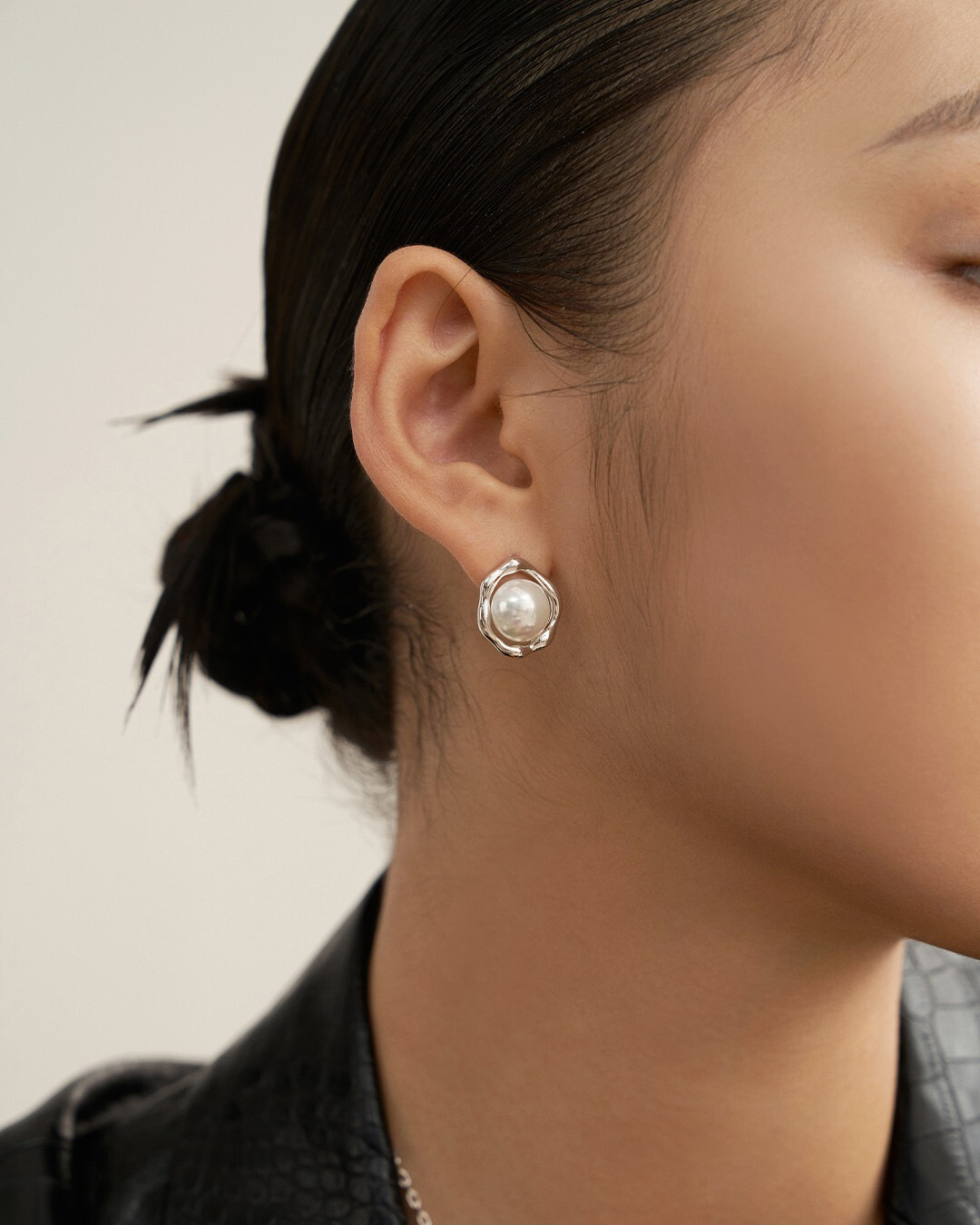 A woman models sunny side up pearl earrings, showcasing elegance and style with a classic pearl earring look.