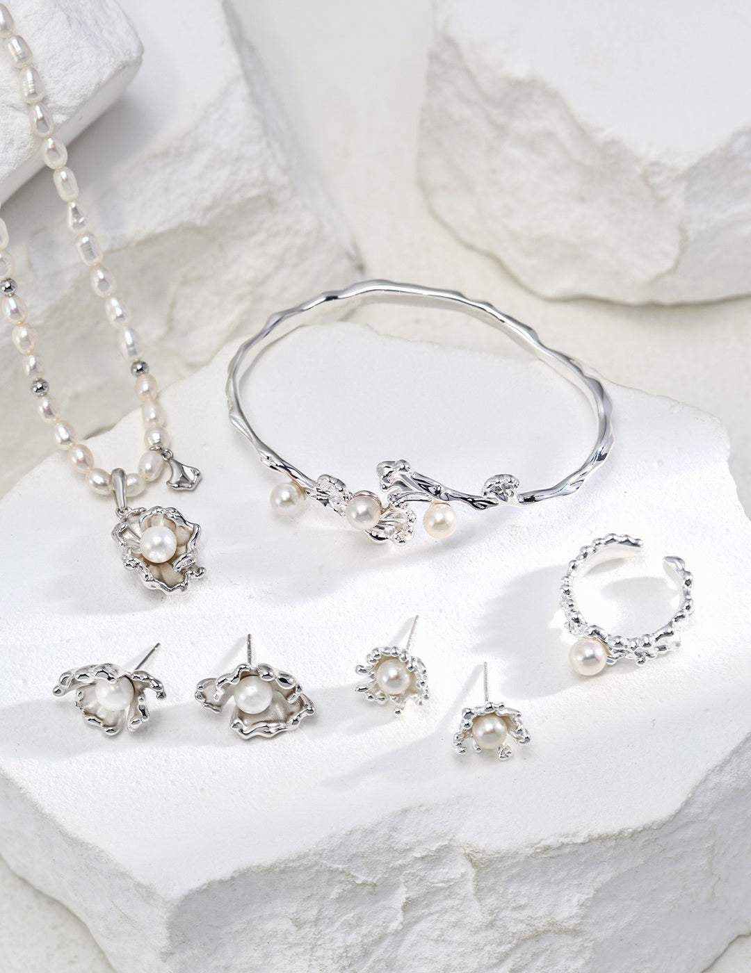A stunning collection of silver jewelry featuring a ring, earrings, and a bracelet elegantly displayed together.