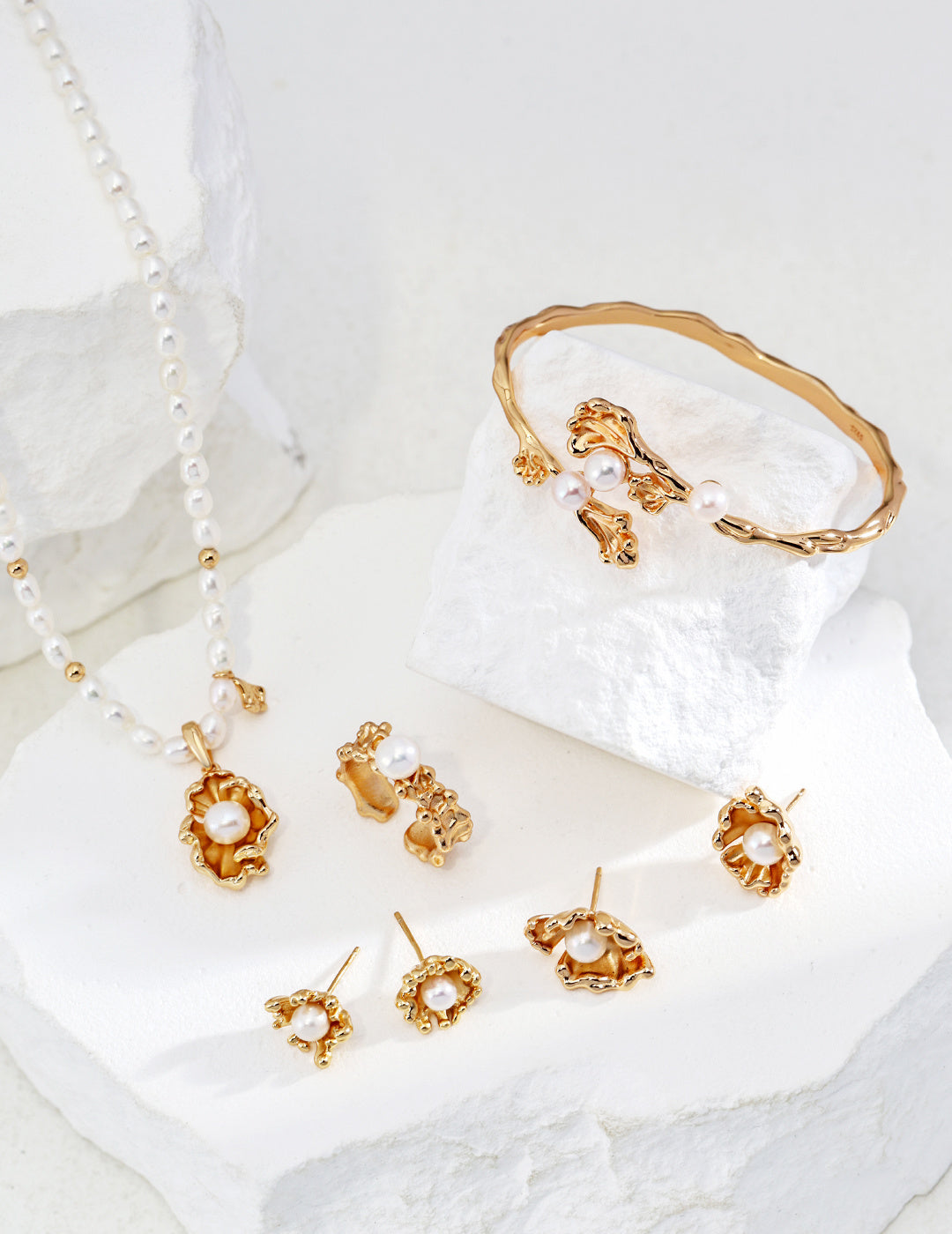 Elegant gold jewelry set featuring pearls and a matching bracelet, perfect for adding a touch of sophistication.