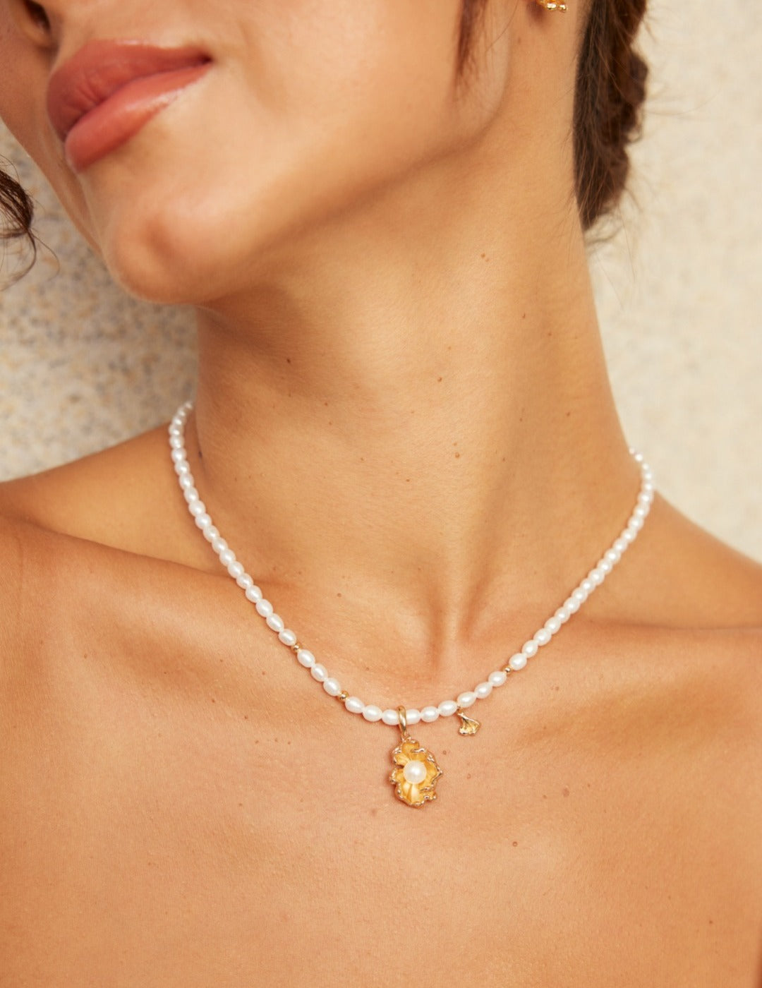 A woman wearing an ocean-inspired necklace featuring a gold star pendant.